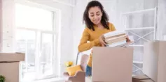 Woman putting household items in a cardboard box